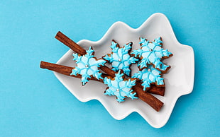 snowflake cookie on white ceramic Christmas tree shaped plate